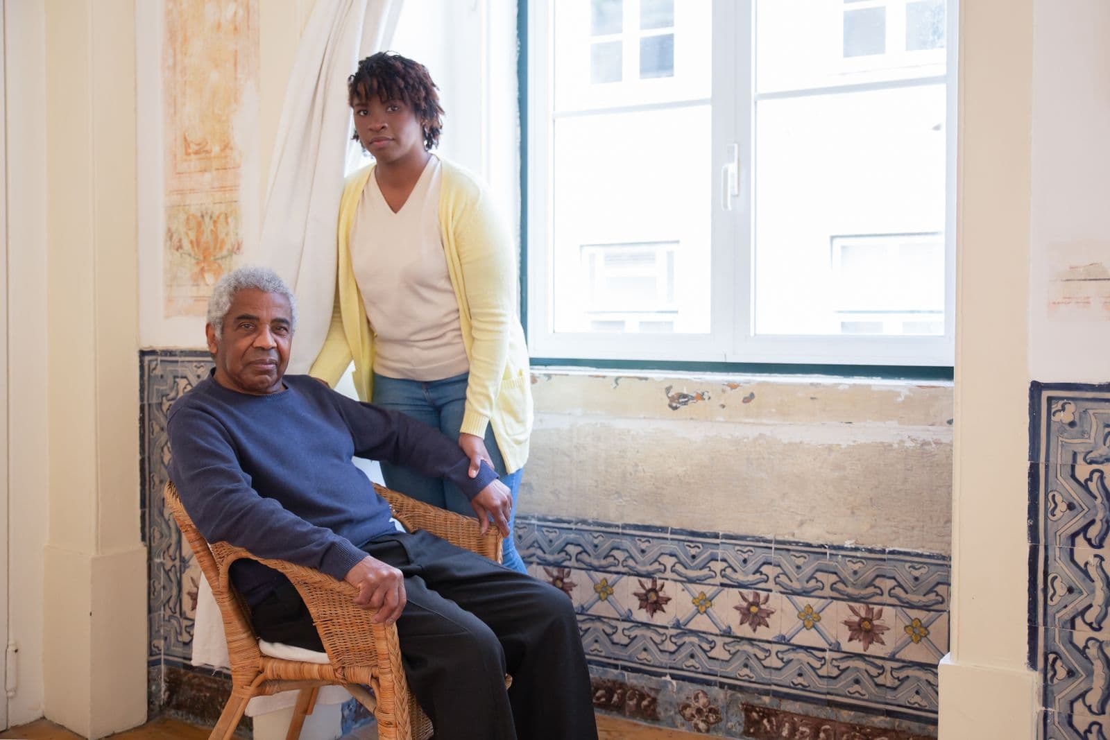 Caregiver chatting with an older man at his dining table