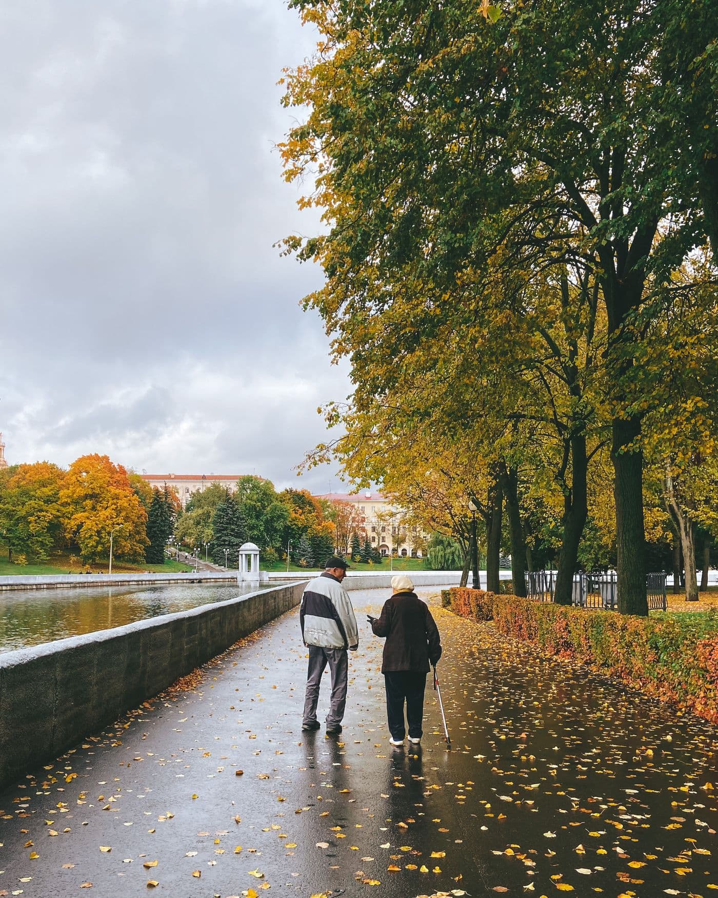 Older couple walking together through an autumn park