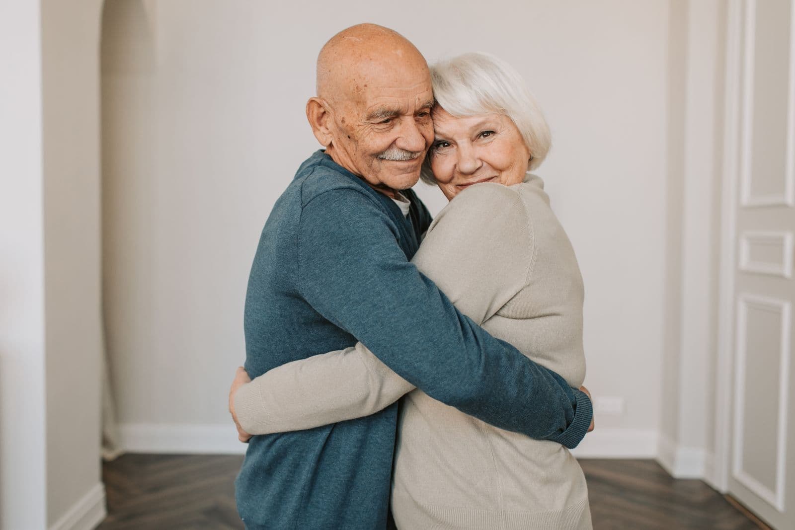 Older man and woman embracing and smiling