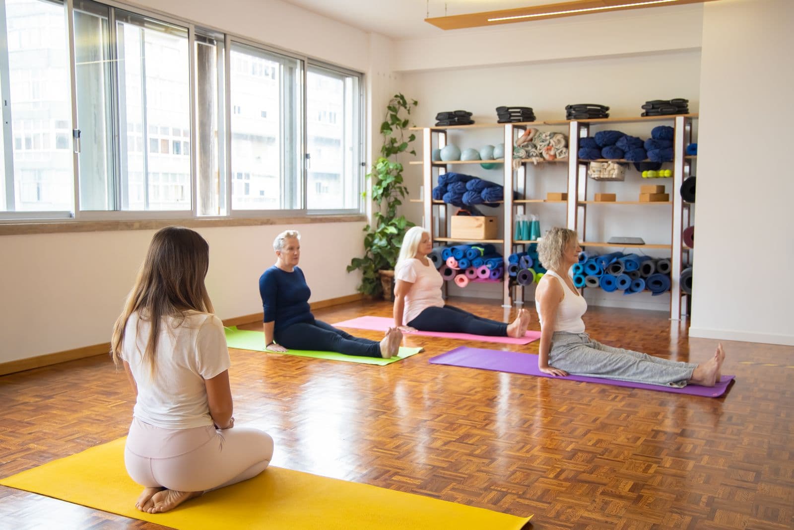 Group of older women practising gentle yoga on mats