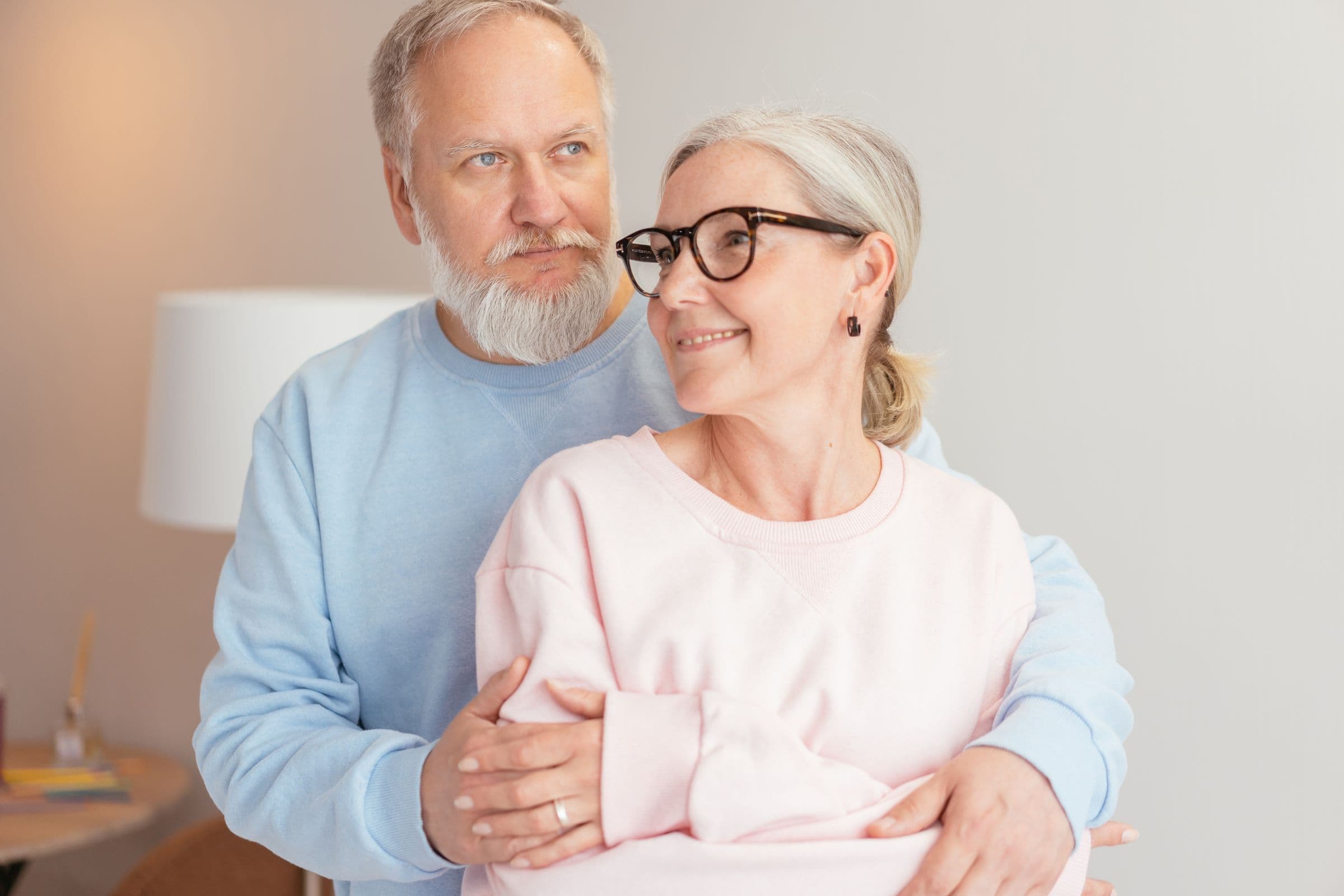 Smiling older couple embracing at home