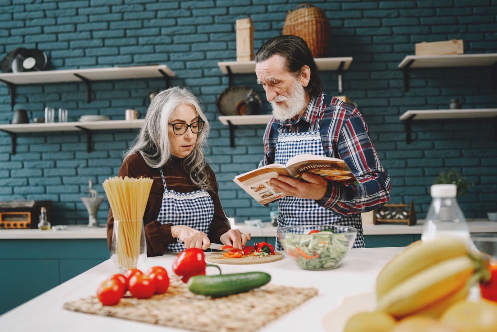 Older couple cooking a healthy meal with fresh vegetables